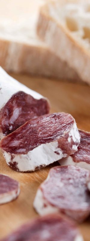 Fuet.Dry cured fuet sausage on wooden table