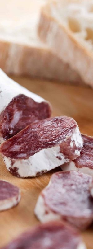 Fuet.Dry cured fuet sausage on wooden table